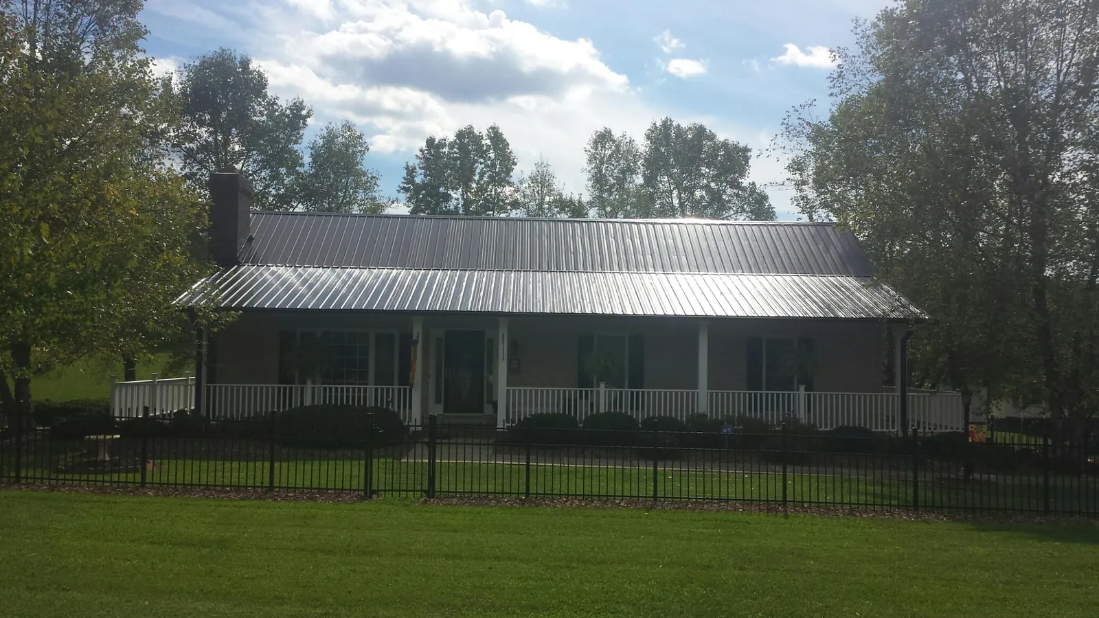 Gray metal roof on a brick ranch with a full width front porch — Gutter Guard Installation work by our crew in Borrego Springs