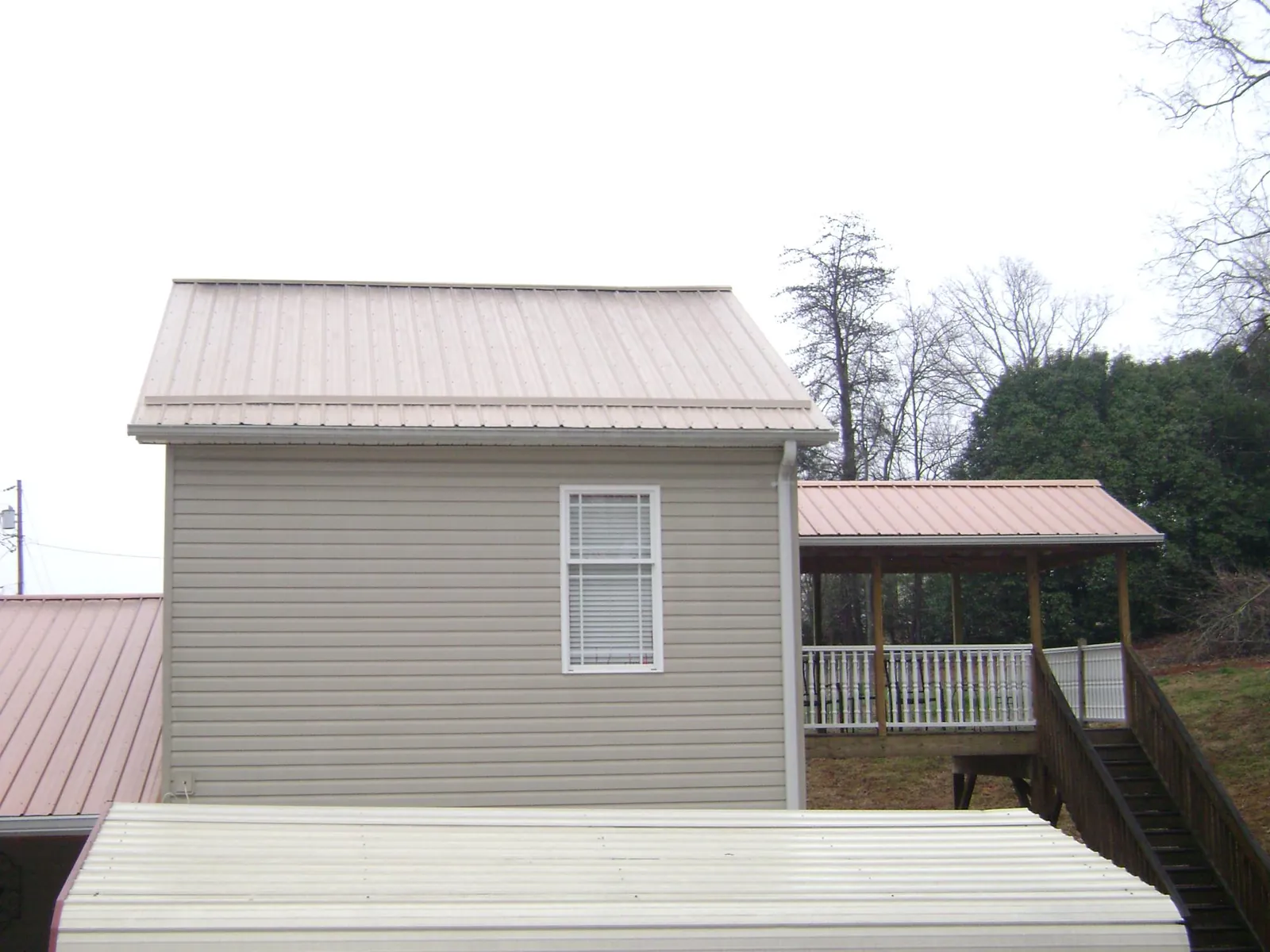 Tan metal roofs on a two story addition and attached porch, from a Roof Replacement job in Borrego Springs